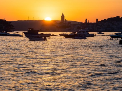 Boats anchoring in a bay, silhouette of a church tower, sunset over Rab, town of Rab, island of