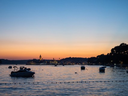 Boats anchoring in a bay, church towers, sunset over Rab, town of Rab, island of Rab, Kvarner Gulf