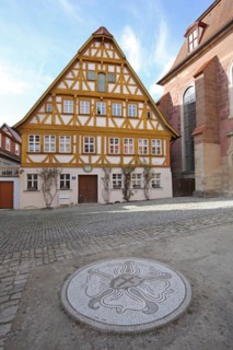 Half-timbered rector's house built in the 16th century and Luther's rose as a symbol of the