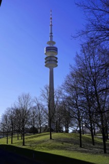 TV tower rises behind bare trees against a clear blue sky, BMW WELT, Munich, Germany, Europe