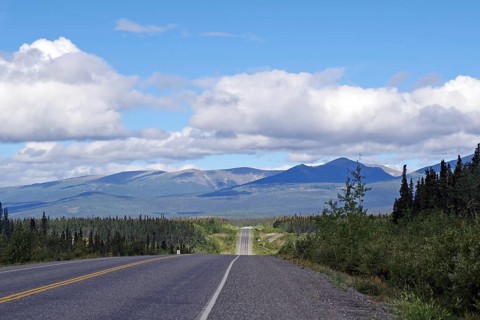 Road without traffic leads through endless forest valleys, late summer, Alaska Highway, Whitehorse,