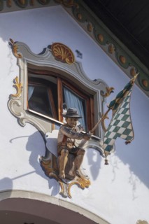Wooden figure of a boy in lederhosen with Bavarian diamond flag white-blue at the Fraundorfer Inn,