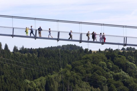 Visitors cross the rope suspension bridge at the Rappbode dam, 483 metres long, 100 metres above