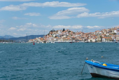 View of a picturesque Mediterranean town with boats and a lively waterfront promenade, Poros, Poros