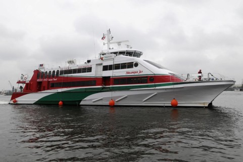 The red and white catamaran 'Halunder Jet' tied between two buoys on the water, Hamburg, Hanseatic