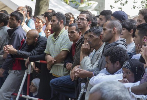 Refugees from Syria wait behind barriers in the central reception centre for asylum seekers at the