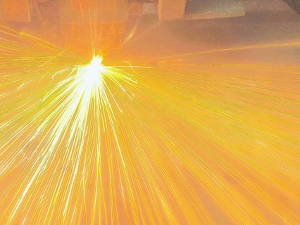 Close up of sparks fly out machine head for metal processing at the factory. Automotive production