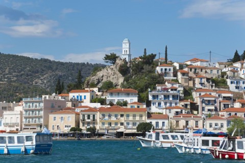 View of an idyllic Mediterranean coastal town with harbour, whitewashed houses and blue sky, view