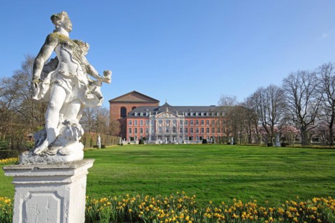 Electoral palace and Constantine basilica with palace garden and white sculpture in spring and