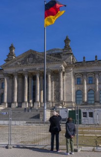 Tourists standing at the construction fence in front of the Reichstag building, Berlin, Germany,
