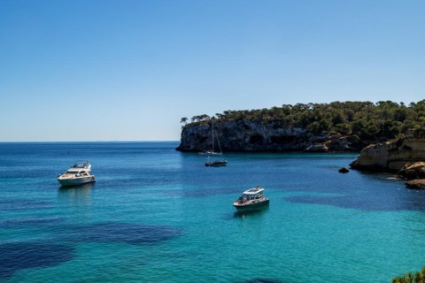 Private boats anchored in the bay in front of Playa El Mago, Cala de Portals Vells, Majorca,