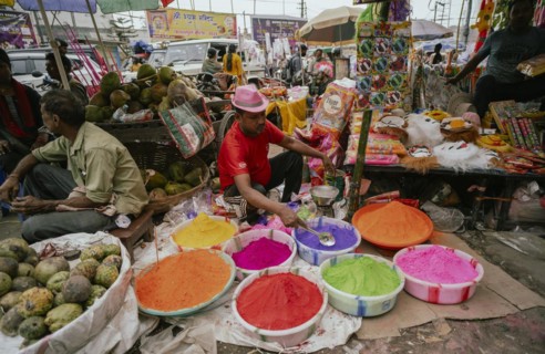 Vendor sells Holi celebration items in a street market, ahead of Holi festival on March 23, 2024 in