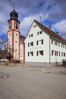 St John's Church and town hall under a blue sky with white cumulus clouds in Bad Krozingen,