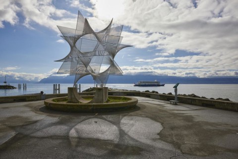 Art object Ouverture au Monde by the artist Angel Duarte with shadow and backlit view of Lake