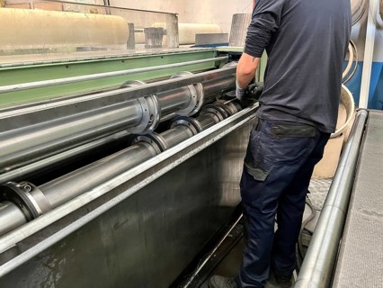 Portrait of a man placing the blades for cutting sheet metal on a metal cutting machine.