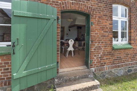 View from the garden into the kitchen of the historic farmhouse from the 19th century, Open-Air