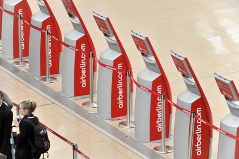 Travellers waiting at a row of self-service check-in machines at the airport, Hamburg, Hanseatic
