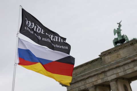 A waving flag with the inscription 'AeoeWiderstand laesst sich nicht verbieten'Aeo and a