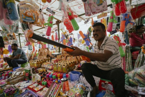 Vendor sells Holi celebration items in a street market, ahead of Holi festival on March 23, 2024 in