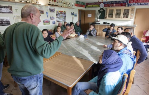 Syrian refugees learn traffic rules during an integration course. An employee of the