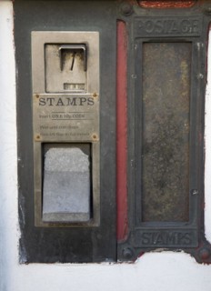 Old disused stamp vending machine and post box, England, UK