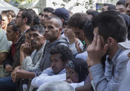 Refugees from Syria wait behind barriers in the central reception centre for asylum seekers at the