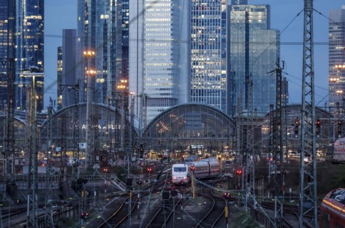 An ICE train leaves Frankfurt Central Station, the Frankfurt skyline with skyscrapers in the