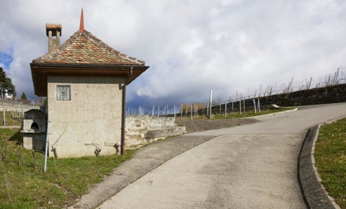 Steep path and historic small house with square floor plan, red roof and chimney in the UNESCO