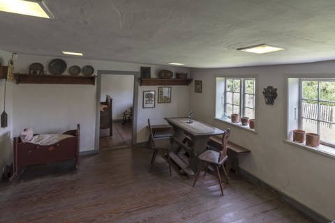 Dining room with cradle in a historic farmhouse from the 19th century, Open-Air Museum of Folklore