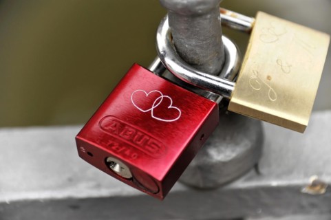 A rusty red love lock with a heart-shaped dovetail on a railing, Hamburg, Hanseatic City of