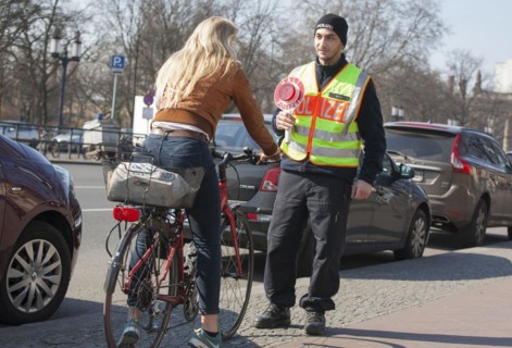 A Berlin police officer stops a cyclist during a traffic stop, 20/03/2018