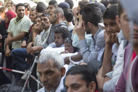 Refugees from Syria wait behind barriers in the central reception centre for asylum seekers at the