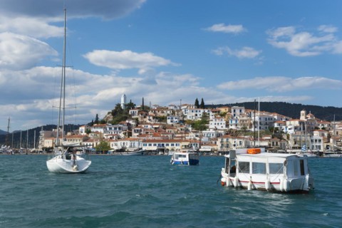 View over a busy harbour with boats and clear sky over a traditional coastal town, view from