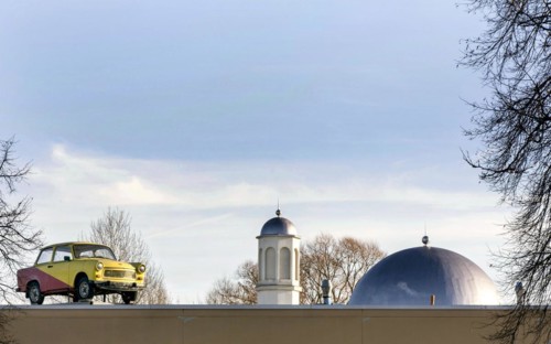 A Trabant on the roof of a workshop, in the background you can see the Khadija Mosque in the Berlin