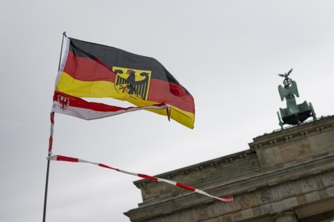 A waving German flag and Brandenburg flag with fluttering tape, the Brandenburg Gate in the