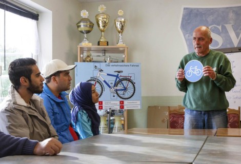 Syrian refugees learn traffic rules during an integration course. An employee of the