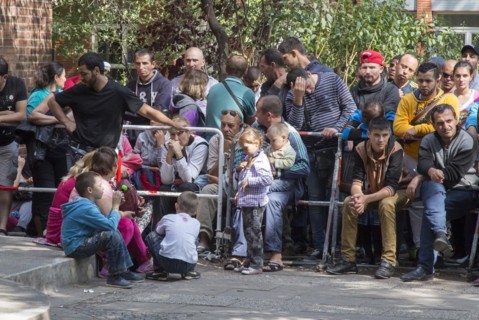 Refugees from Syria wait behind barriers in the central reception centre for asylum seekers at the