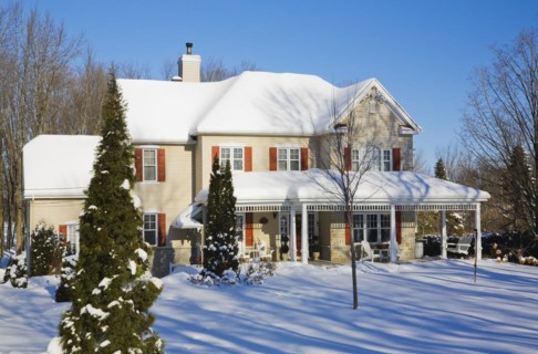 Two story beige vinyl siding with brownish red nuanced brick veneer and orange trim home in winter,