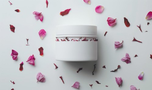 Blank creme jar mockup with scattered flower petals on a white background, beauty in nature AI