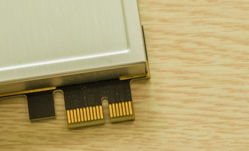 A dongle device with gold contacts lying next to a beige surface, in South Korea
