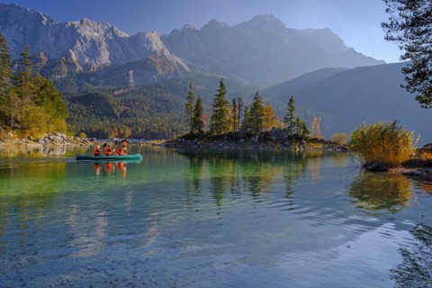 Canoeists on a mountain lake in front of steep mountains, reflection, evening light, autumn, Eibsee