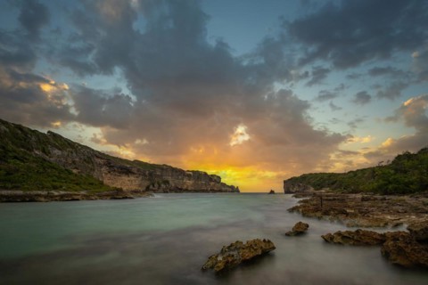 Rocky coast, long bay by the sea at sunset. Dangerous view of the Caribbean Sea. Tropical climate