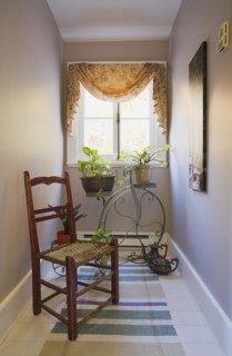 Antique wooden weaved seat chair and ornamental Penny-Farthing bicycle support stand for planters