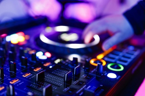 Hand of a DJ on a mixing desk, also called DJ controller or DJ console, at a party, Cologne, North