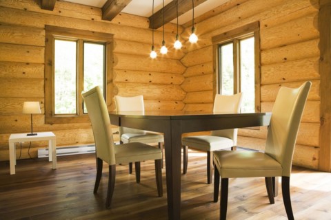 Brown wooden table and white cotton cloth upholstered high back chairs in dining room inside