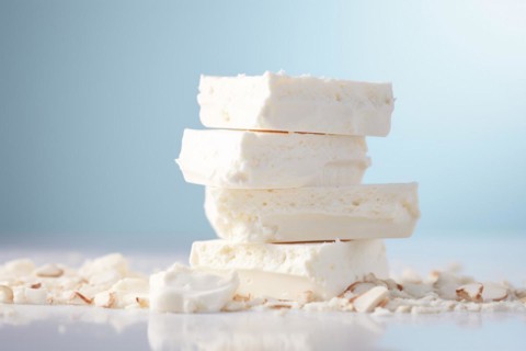STack of white nougat on pastel blue studio background. KI generiert, generiert, AI generated