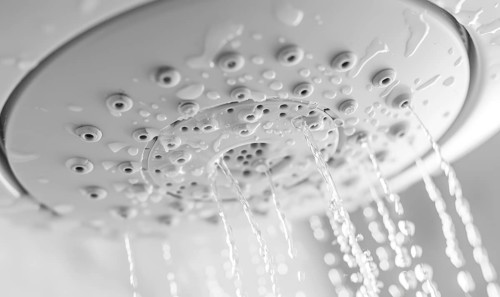 Water streaming from a shower head against a pristine white background AI generated