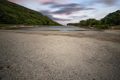 Rocky coast, long bay by the sea at sunset. Dangerous view of the Caribbean Sea. Tropical climate