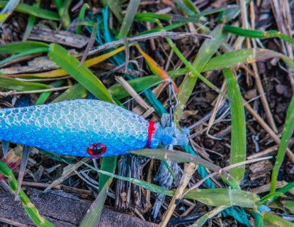 Close-up of a blue fishing lure on the ground, part of outdoor angling gear, in South Korea