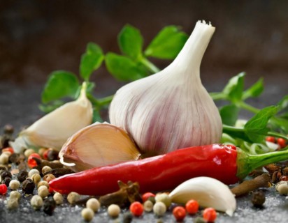 Fresh garlic arranged with red chilli, colourful peppercorns and green herbs, AI generated, AI